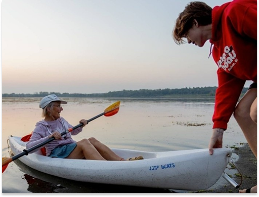 Wingra boats staff helping a woman in a kayak